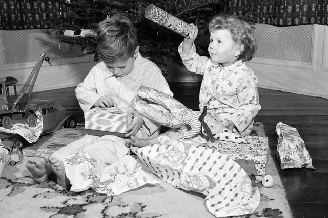 Two Edinburgh tots, John and Donna, with all their presents on Christmas morning