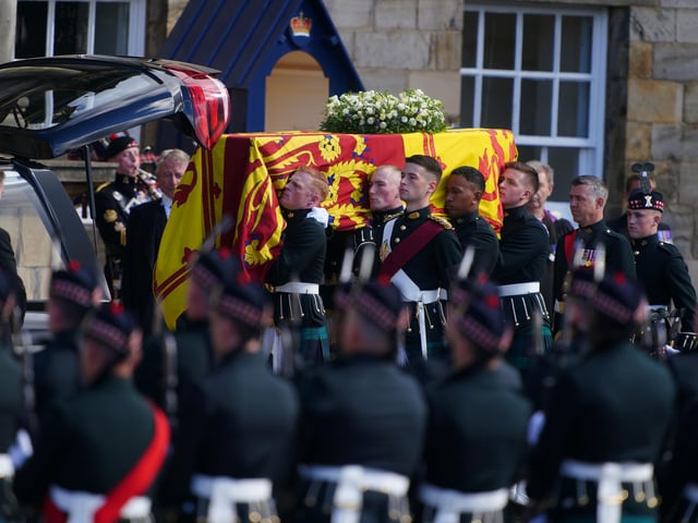 RETRANSMITTING AMENDING BYLINE Royal guards carry Queen Elizabeth II's coffin at the start of the procession from the Palace of Holyroodhouse to St Giles' Cathedral, Edinburgh. Picture date: Monday September 12, 2022.
