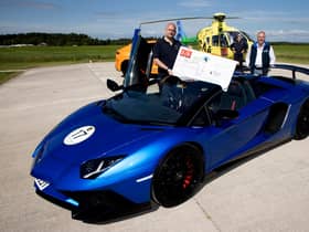 Andy Canning General Manager of Lamborghini Edinburgh pictured handing over a cheque for £500 to Nick Harvey Director of Fundraising & Communictaions at SCAA