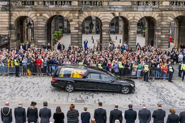 The hearse carrying the coffin of Queen Elizabeth II, draped with the Royal Standard of Scotland, passes the City Chambers on the Royal Mile. Picture: Jane Barlow/PA Wire