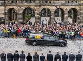 The hearse carrying the coffin of Queen Elizabeth II, draped with the Royal Standard of Scotland, passes the City Chambers on the Royal Mile. Picture: Jane Barlow/PA Wire