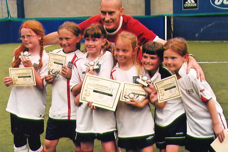 These young footballers score trophies and certificates in 2006 but  do you know what the competition was and who is on the photo with them?