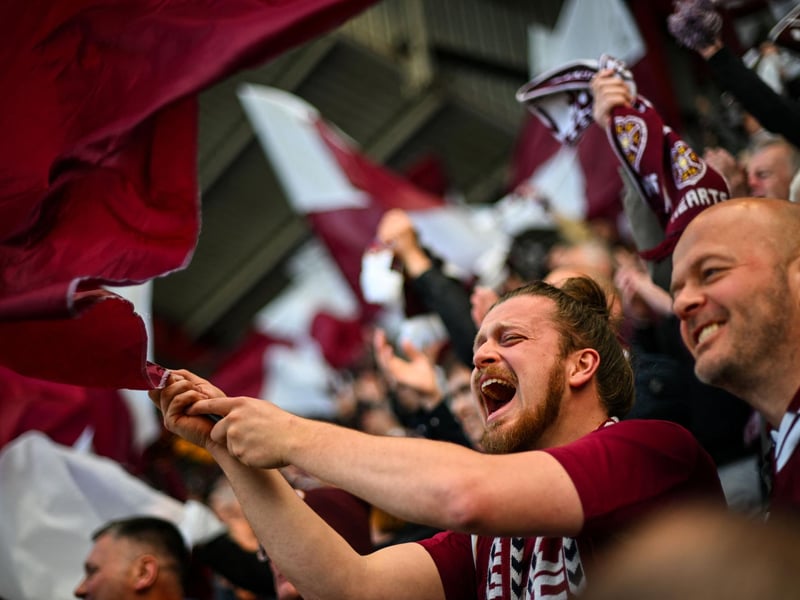 Hearts fans cheer before the start of the match (Photo by ANDY BUCHANAN / AFP via Getty Images)
