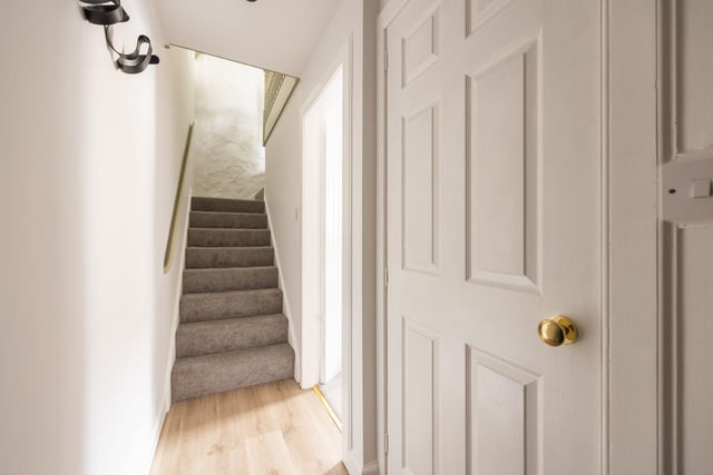 The beautiful accommodation includes a secure entry system and this welcoming hallway with small storage cupboard.
