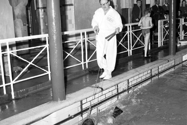 Instructor Norman Sarsfield is pictured teaching children to swim at Dalry baths using the harness and flippers, in January 1966.