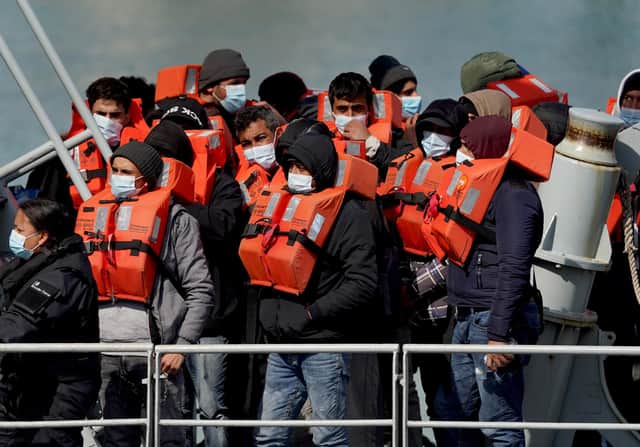 A group of people thought to be migrants are brought in to Dover, Kent, following a small boat incident in the Channel. Under a scheme designed to crack down on migrants landing on British shores after crossing the Channel in small boats, the UK intends to provide those deemed to have arrived unlawfully with a one-way ticket to Rwanda. Picture date: Friday April 15, 2022.