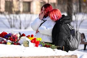 A young woman cries after laying flowers for late Russian opposition leader Alexei Navalny at the Solovetsky Stone, a monument to political repression that has become one of the sites of tributes for Navalny. (Photo by NATALIA KOLESNIKOVA/Getty Images)