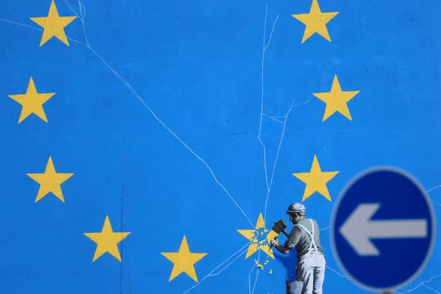 A Brexit-inspired mural by the artist Banksy shows a worker removing a star from the Flag of Europe (Picture: Gareth Fuller/PA)