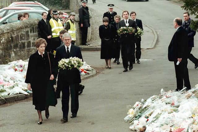 Prime Minister John Major and opposition leader Tony Blair bring their floral tributes to Dunblane Primary School after the shooting (Getty Images)