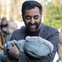 Humza Yousaf holds a baby during an event in Glasgow as he campaigns to become the next SNP leader (Picture: Jeff J Mitchell/Getty Images)