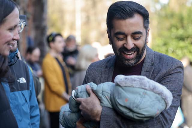 Humza Yousaf holds a baby during an event in Glasgow as he campaigns to become the next SNP leader (Picture: Jeff J Mitchell/Getty Images)