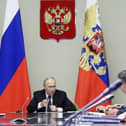 Russian President Vladimir Putin, left, leads a meeting with top security and defense officials about the situation in Kursk and Belgorod border regions