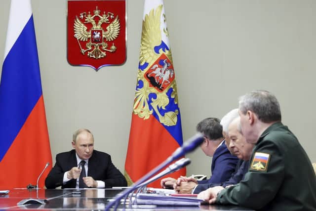 Russian President Vladimir Putin, left, leads a meeting with top security and defense officials about the situation in Kursk and Belgorod border regions