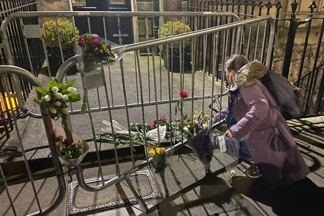 A protestor lays flowers during a gathering outside the Russian Consulate in Edinburgh on Friday night after the death in prison of opposition politician and anti-corruption campaigner Alexei Navalny