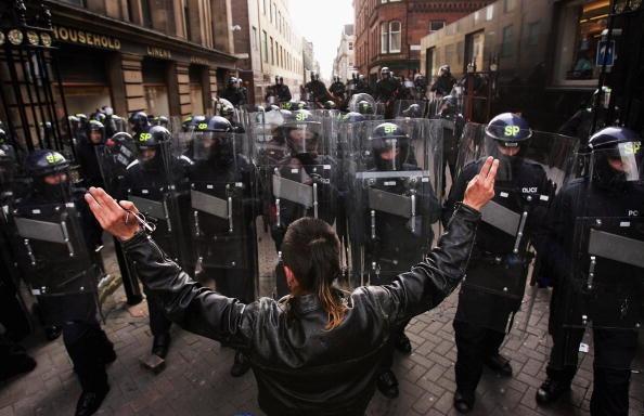 A protester stands in front of an advancing line of riot police on North St David Street on July 4, 2005.