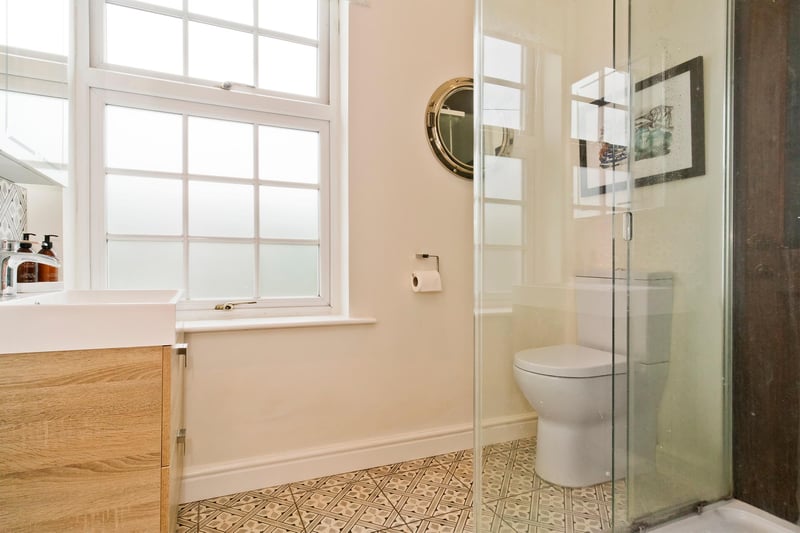 The en-suite shower room, which also houses a Bluetooth wall cabinet.