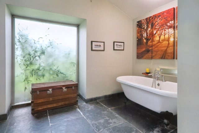 The downstairs bathroom/wet room has a large frosted window and standalone bathtub.