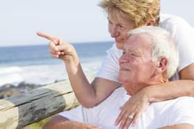 An elderly couple enjoy a visit to the beach