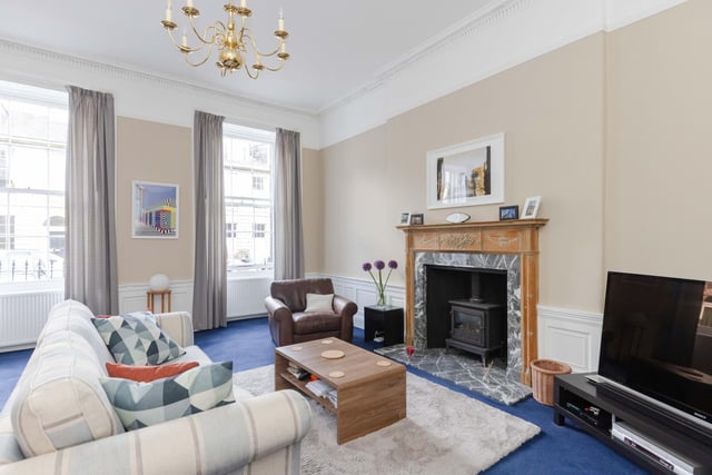 Bright spacious twin window living room which retains working shutters, period cornice, ceiling rose, timber panelling and period mantle with gas stove.
