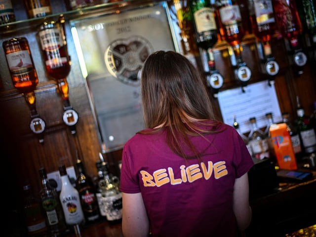 A Hearts fan has pre-match drinks at the Tynecastle Arms pub  (Photo by ANDY BUCHANAN / AFP via Getty Images)