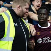 Garang Kuol celebrates with the Hearts support after equalising at Ibrox. Picture: SNS