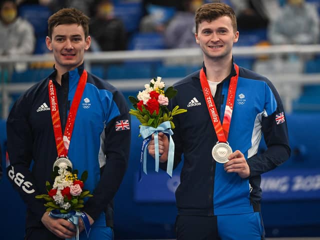 Silver medallists Britain's Grant Hardie and Bruce Mouat pose on the podium during the Beijing 2022 Winter Olympic Games men's curling competition