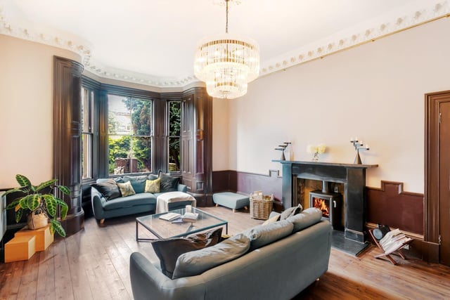 Fronted by a southeast-facing bay window, the living room is the place to relax. It enjoys soothing décor, highlighted by ornate cornice work, and is framed by an imposing mantelpiece inset with a log-burning stove.