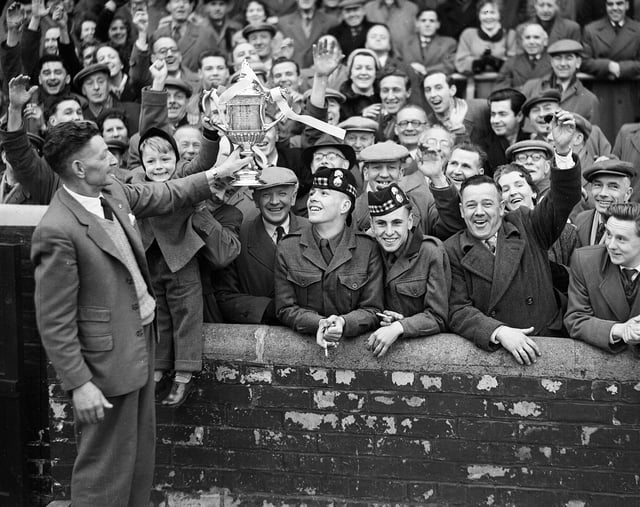 Fans celebrate Hearts' 1956 Scottish Cup win with groundsman Mathie Chalmers.