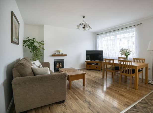 The property’s generously proportioned and light-filled living room is open-plan to the kitchen