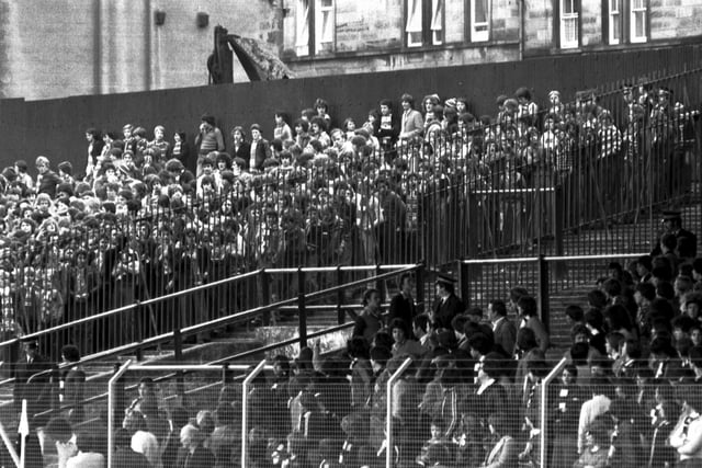 Hearts fans and Rangers fans are separated by fences and a section of terracing for the Hearts v Rangers football match at Tynecastle in October 1978.