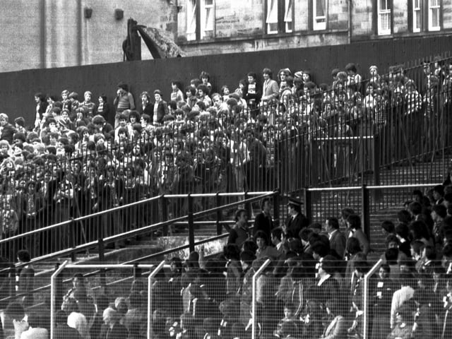 Hearts fans and Rangers fans are separated by fences and a section of terracing for the Hearts v Rangers football match at Tynecastle in October 1978.