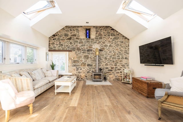 The property's large lounge area comes with a rustic log burner in this bright and airy space.