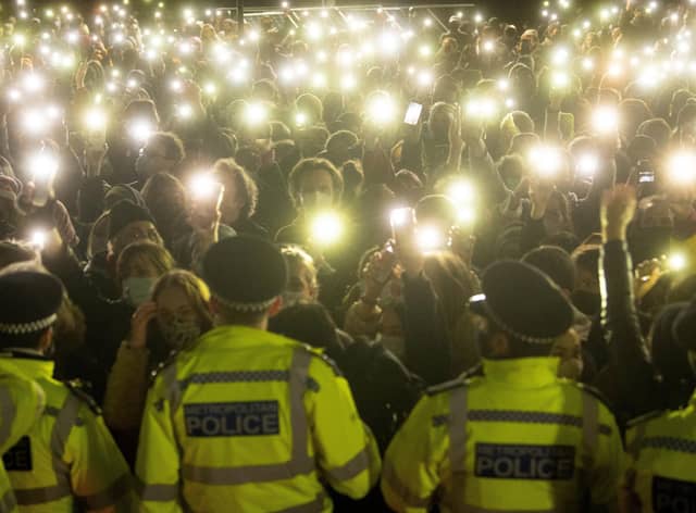 People in the crowd turn on their phone torches as they gather in Clapham Common, London