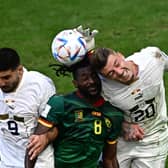 Cameroon's Andre-Frank Zambo Anguissa and Serbia's Sergej Milinkovic-Savic compete to head the ball during the two teams' World Cup group match (Picture: Anne-Christine Poujoulat/AFP via Getty Images)