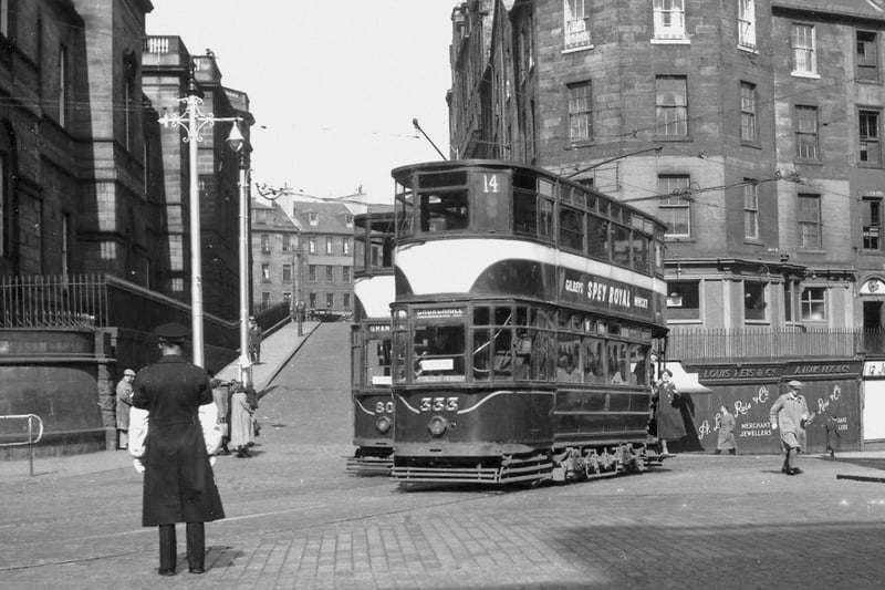 A tram is pictured in the 1950s turning onto Princes Street at the top of Leith Street, with the site of what is now St James Quarter in the background.