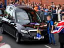 A young fan places a rose on the hearse as the funeral procession makes it's way past the Ibrox Stadium following the funeral of Rangers kitman Jimmy Bell
Pic: Andrew Milligan
