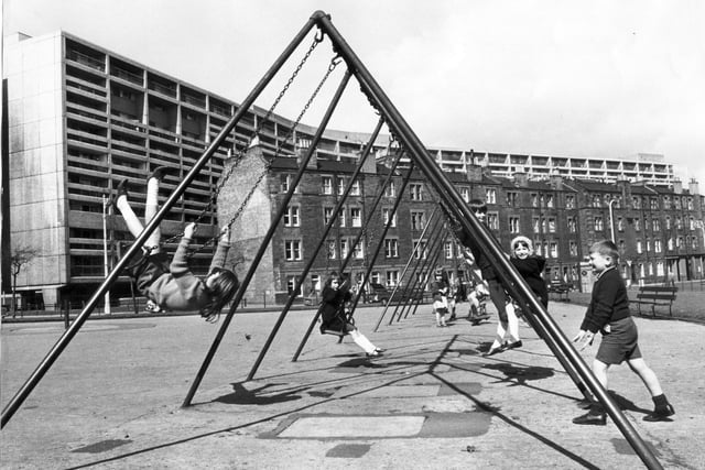 Children playing in a park in Henderson Gardens, Leith. Cables Wynd Banana Flats in the background.
