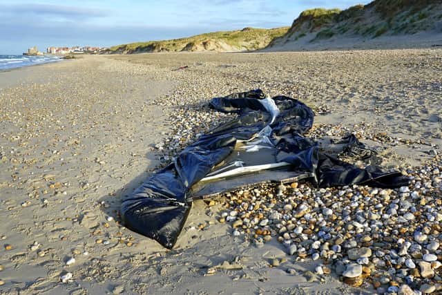 A stock image of deflated dinghy on the beach in Wimereux near Calais.