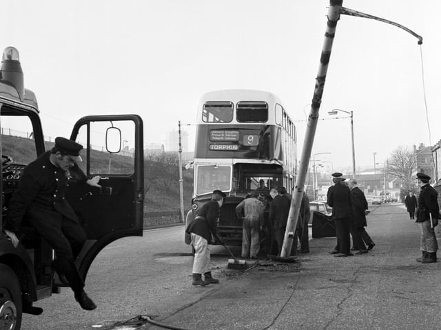 Police, firemen and an Edinburgh City Transport employee look at the damage after a number 9 bus crashed into a lamppost in Granton in November 1974.
