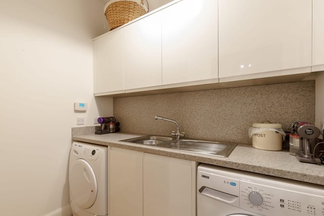 The handy utility room with washing machine and tumble dryer and cupboard housing a hot water tank.