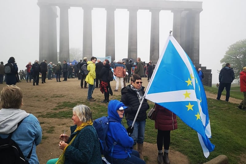 One protester holds a pro Scottish independence flag in front of the National Monument.