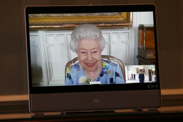 Queen Elizabeth II appears on a screen by videolink from Windsor Castle, where she is in residence, during a virtual audience to receive Her Excellency Ivita Burmistre, the Ambassador of Latvia, at Buckingham Palace, London.