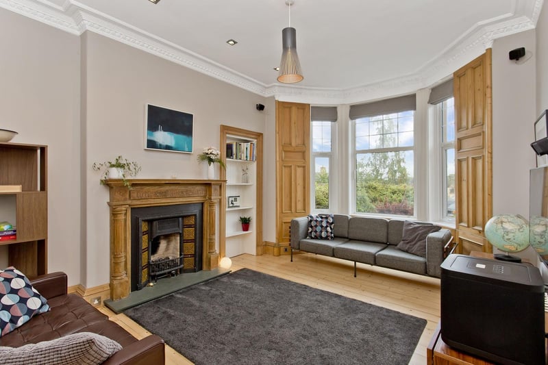 The impressive living room is fronted by a large bay window with a traditional panelled surround.