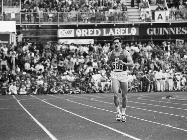 Scottish athlete Allan Wells runs in to present the Queen's baton to Prince Philip at the opening ceremony of the Edinburgh Commonwealth Games 1986.