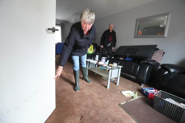 Jean Hendrie and William Craik cleaning their house in Pyothall Court in Broxburn, West Lothian after flooding.