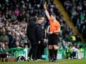 Referee Steven McLean shows the yellow card to Hibs boss Lee Johnson