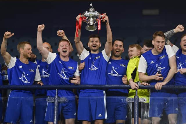 Tollcross captain Stewart O'Neill lifts the trophy at the end of the 100th Scottish Amateur Cup final, the Edinburgh side fighting back from 3-0 down to win on penalties against  Drumchapel at Hapmden