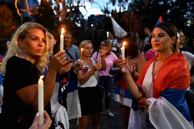 Members of the local Serbian community gather for a vigil outside a hotel where Serbia's tennis champion Novak Djokovic is reported to be staying in Melbourne on January 6, 2022, after Australia said it had cancelled Djokovic's entry visa after having failed to "provide appropriate evidence" of double vaccination or a medical exemption. (Image credit: WILLIAM WEST/AFP via Getty Images)