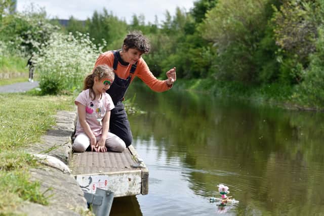 Artist Sarah Kenchington helps a young artist steer a float on the banks of the Union Canal. Picture Julie Howden