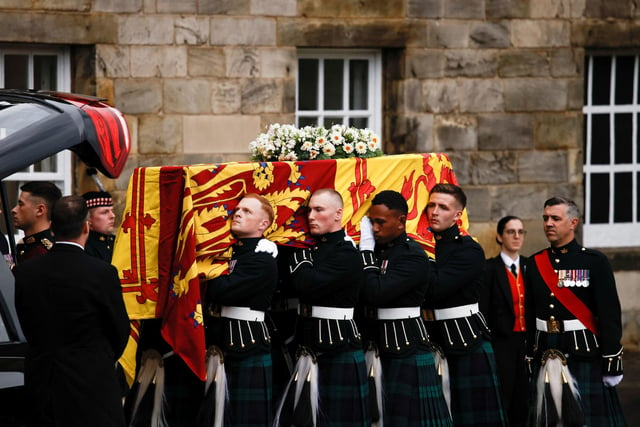 Pallbearers carrying the coffin of Queen Elizabeth II, draped with the Royal Standard of Scotland, as it arrives at Holyroodhouse, Edinburgh where it will lie in rest overnight.